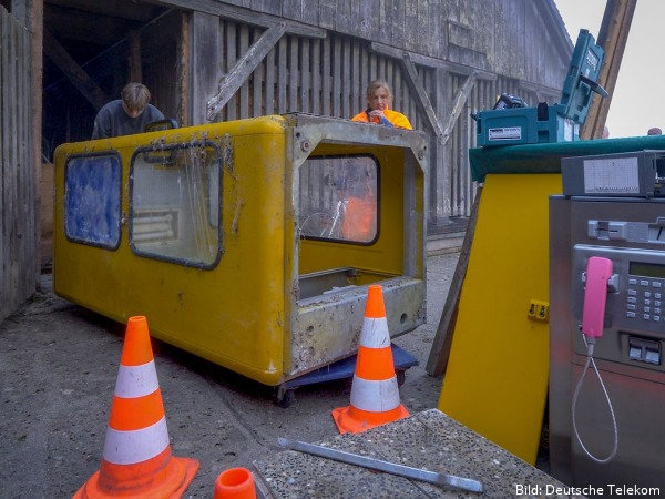 Das gelbe Telefonhäuschen wird ausgebaut und abtransportiert